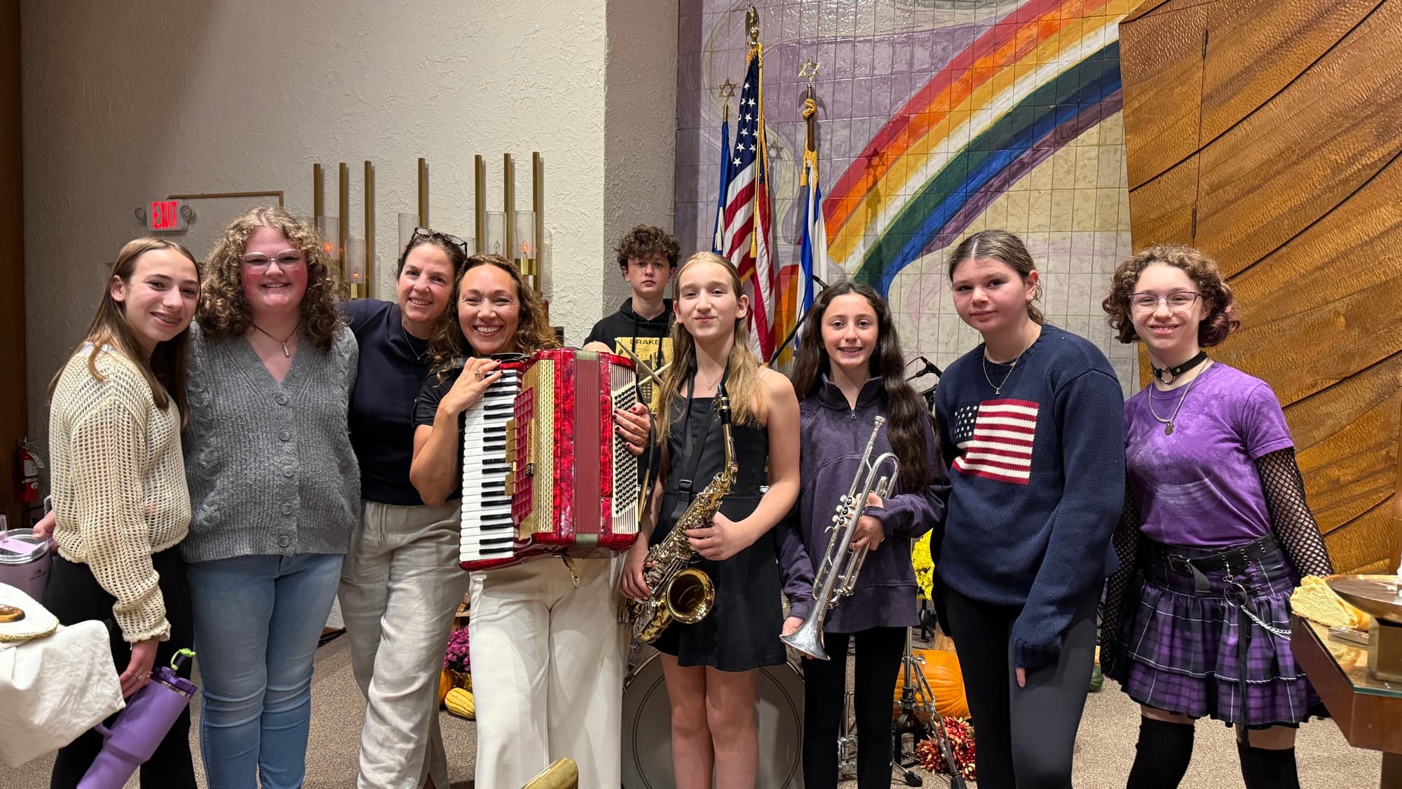 Cantor Anna with a group of young musicians holding instruments in the sanctuary