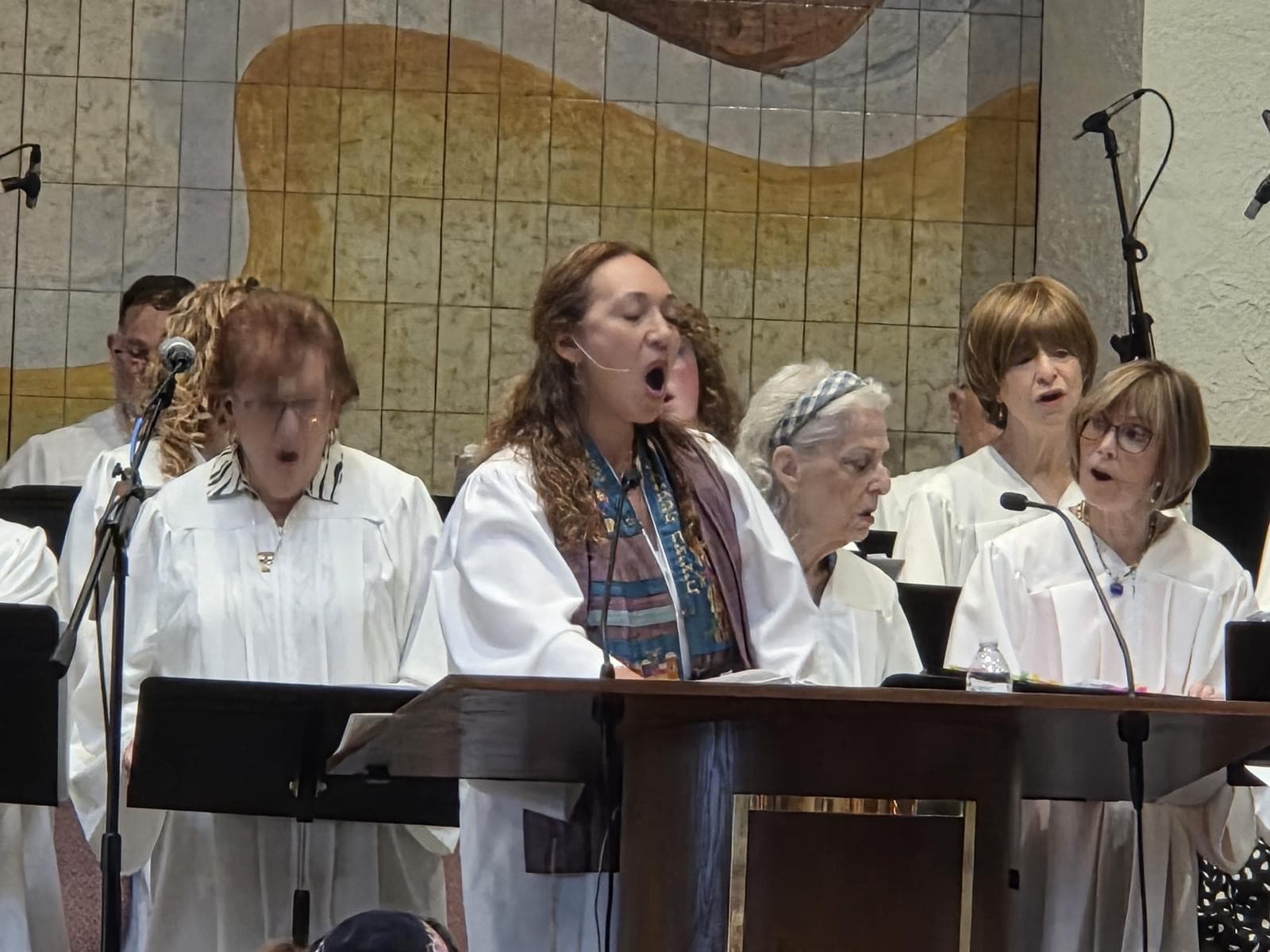 Cantor Anna leading the choir in white robes during High Holiday services