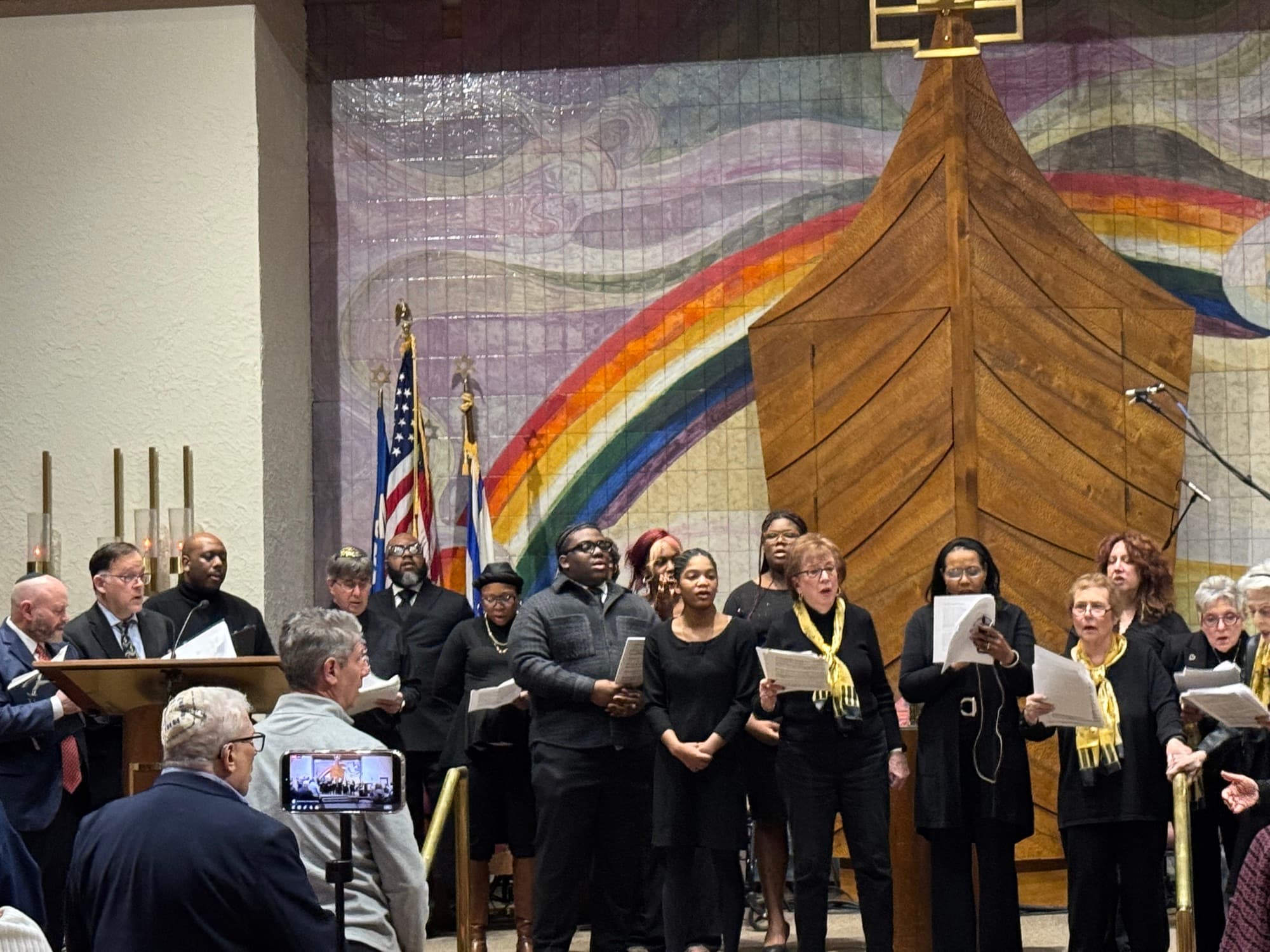 Interfaith choir performing together in front of the Noah's Ark tapestry