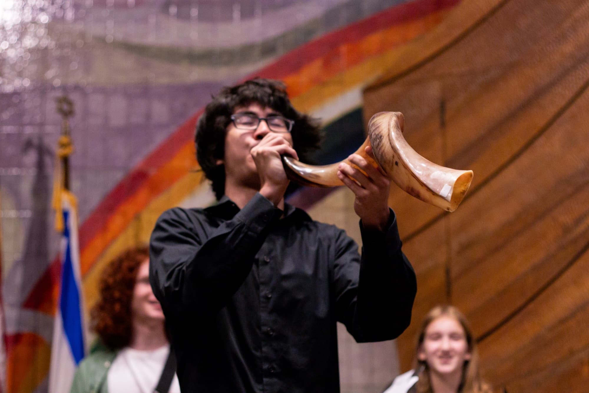 A young person blows the shofar during High Holiday services